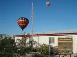 Hot air balloons float over a structure